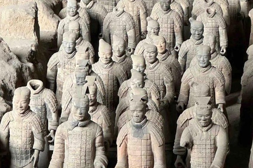 Una hilera de soldados de terracota antiguos, vestidos con uniforme. 1
