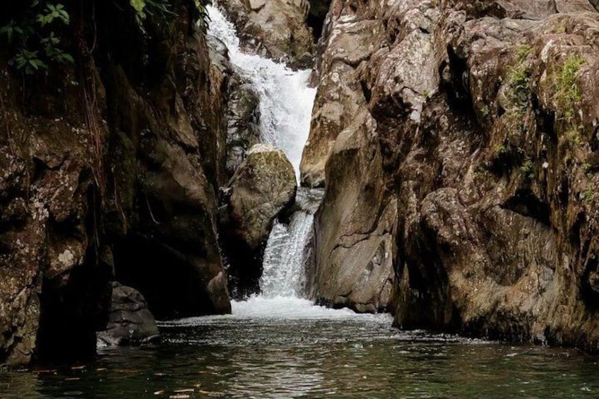 A waterfall cascading down a rocky cliff into a pool of water. 2