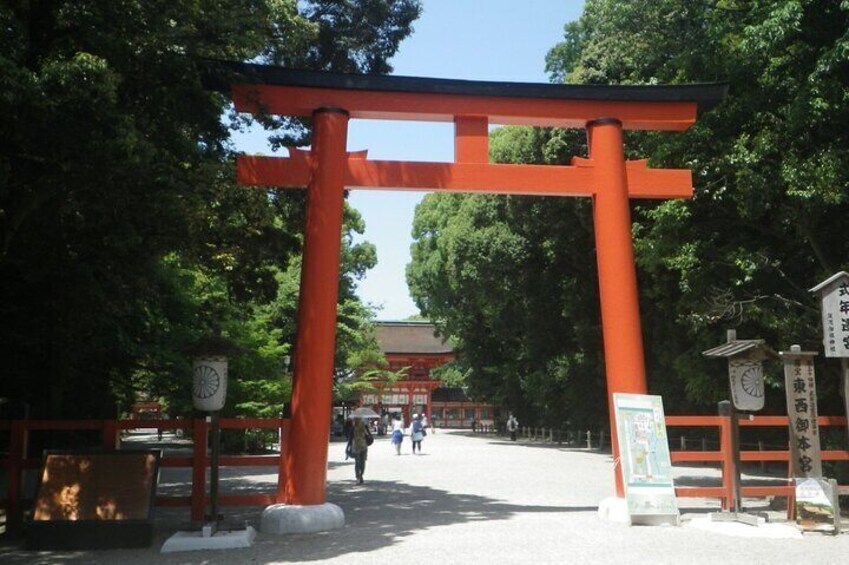 A traditional Japanese torii gate with a clock and informational signs. 2