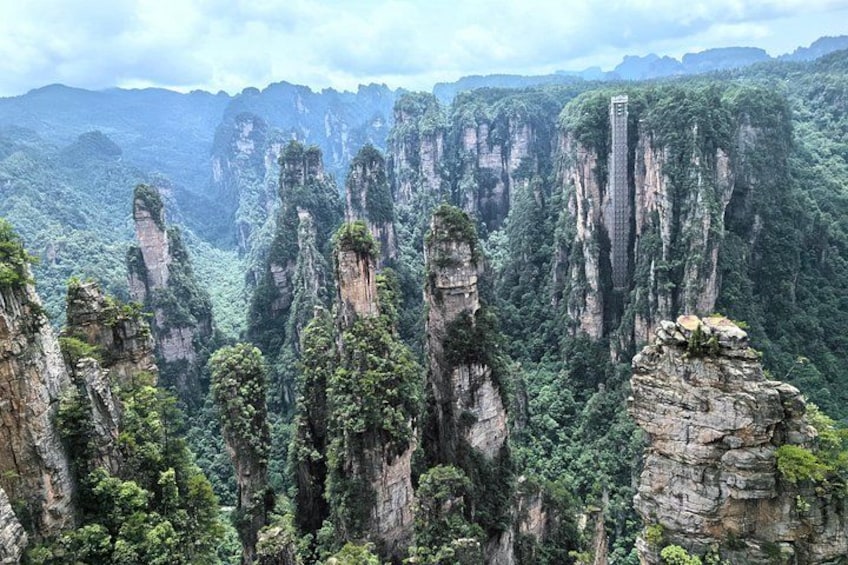 Towering limestone karst peaks, dense forest, and a narrow bridge. 3