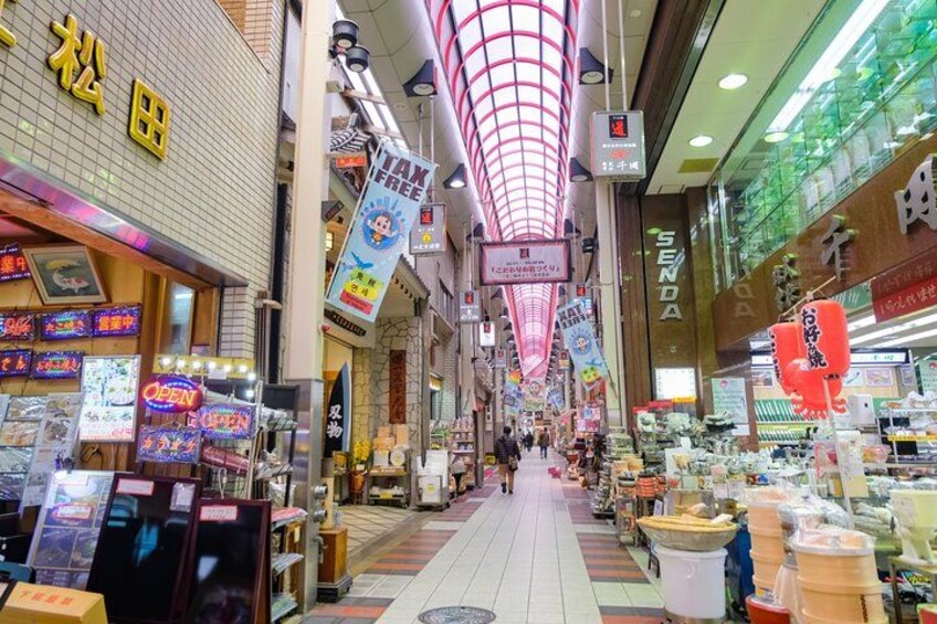 Un marché couvert animé, avec de nombreux commerces et étals vendant divers produits. 4
