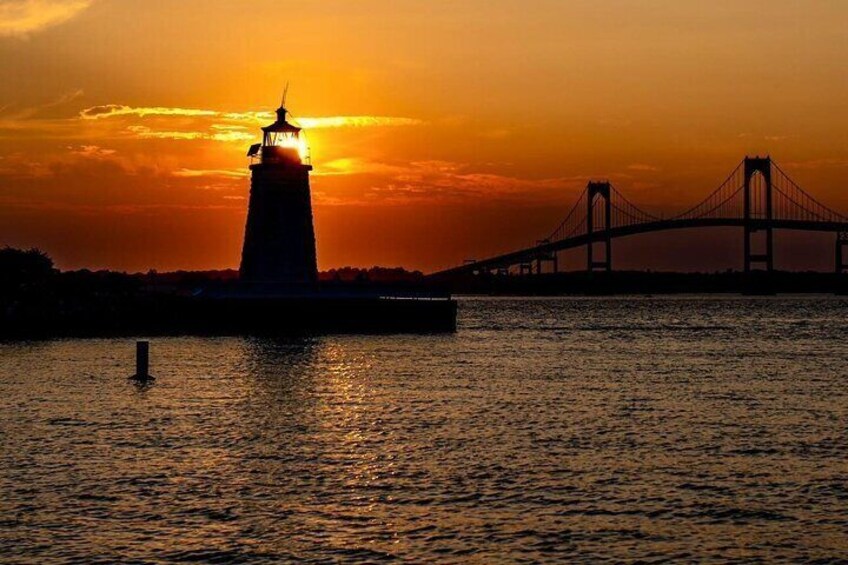 A lighthouse and a bridge during sunset. 2