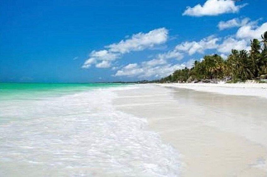 A beach with white sand, turquoise water, and palm trees. 5