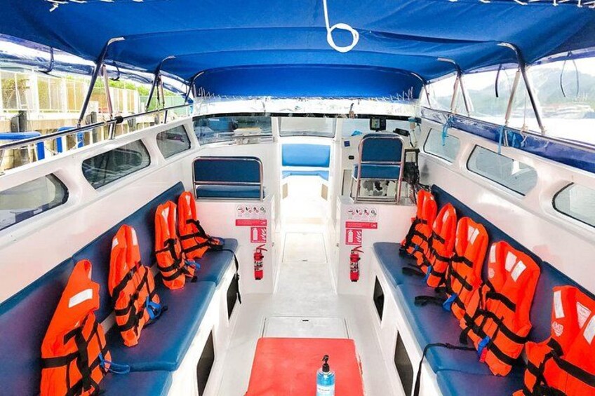 Interior de embarcación con hileras de chalecos salvavidas naranja y un felpudo rojo. 5