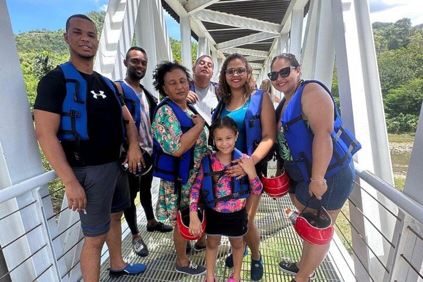A group of people on a bridge with white railings and a metal walkway. 3