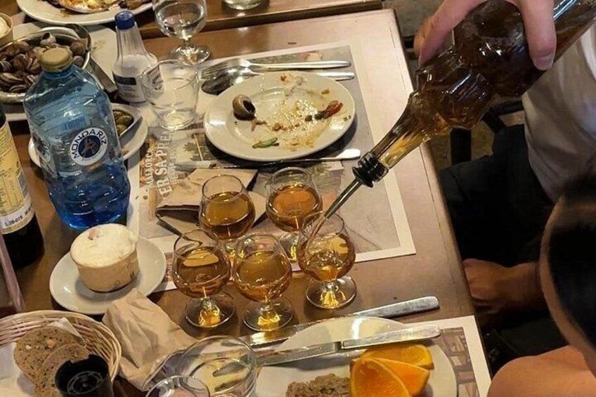 Een eettafel met borden, glazen en een fles waarvan inschenking plaatsvindt. 5