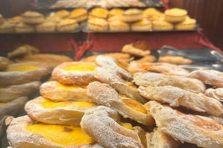 A variety of pastries and baked goods displayed in a bakery. 3