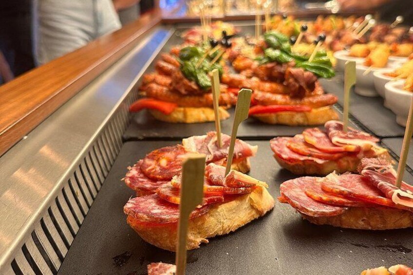 Een buffet met diverse gerechten, waaronder belegde broodjes met vlees en groenten, gepresenteerd op een schaal. 3