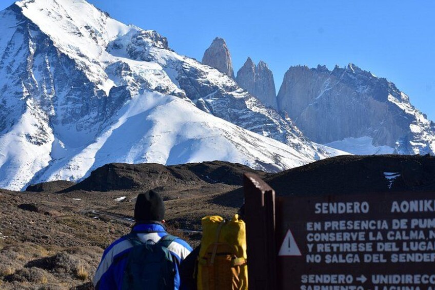 Paisaje montañoso con un letrero que advierte sobre la presencia de una bomba y aconseja mantener la calma y no abandonar el remitente. 1