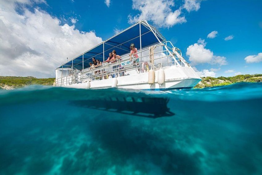 Un'imbarcazione con persone a bordo che galleggia su un'acqua cristallina turchese. 3