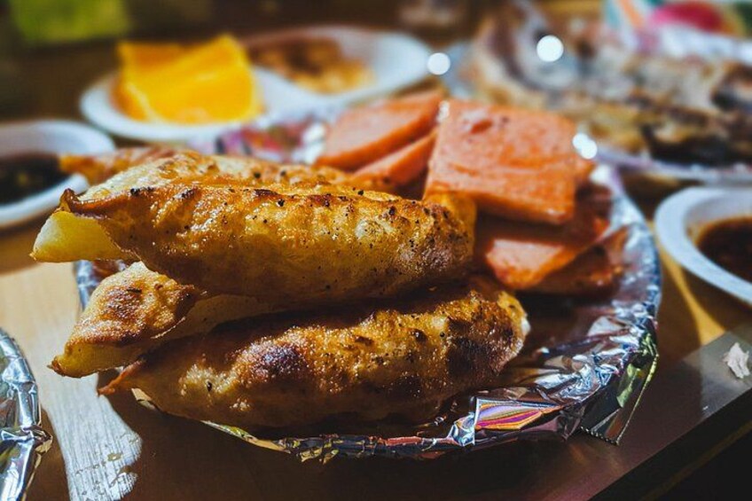 A plate of grilled chicken wings and a slice of pineapple. 2