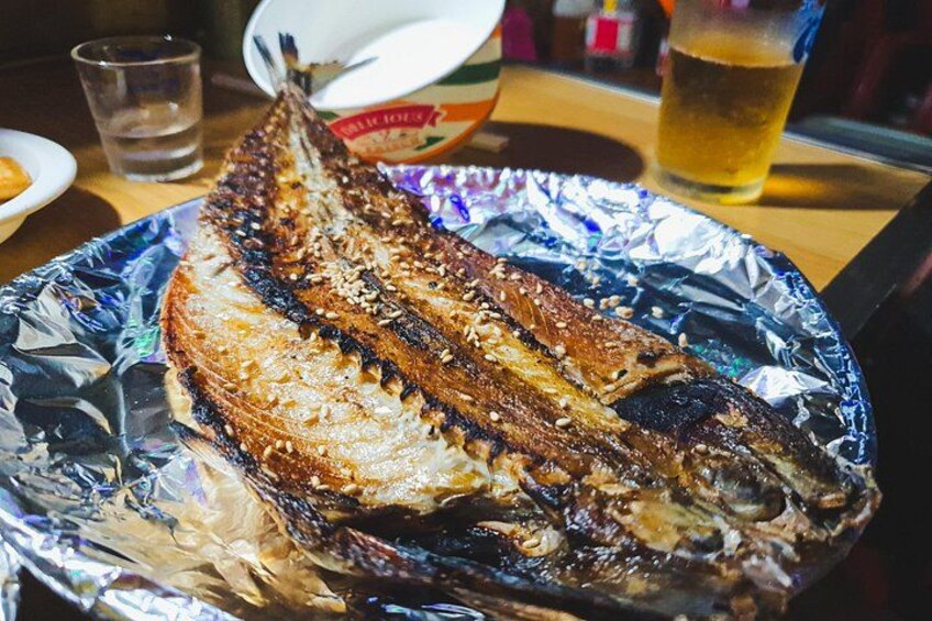 A grilled fish on a foil plate. 3