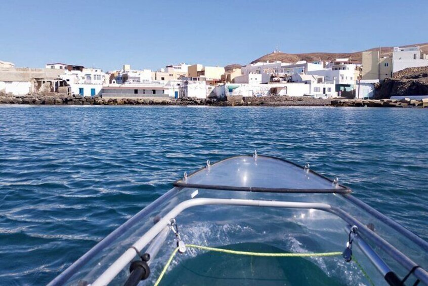 A boat on water with a coastal village in the background. 1