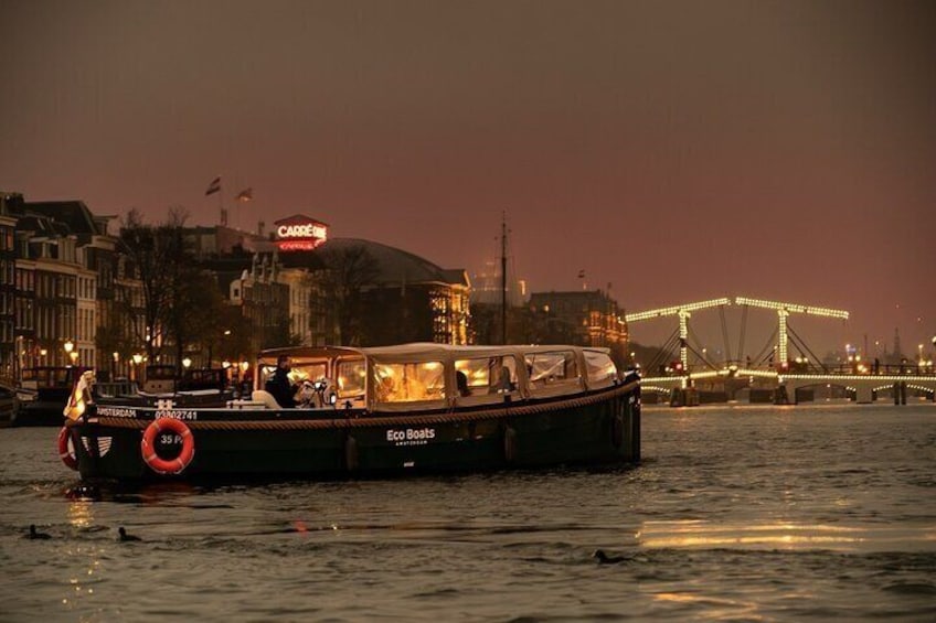 Un bateau appelé « Eco Boats » navigue sur une rivière, avec un pont en arrière-plan. 2