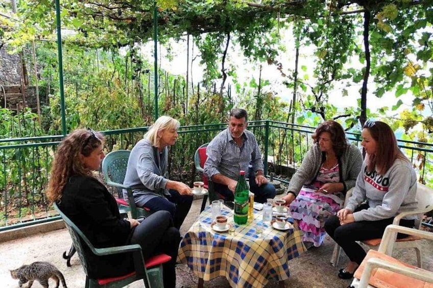 Un gruppo di persone sedute a un tavolo all'aperto, chiacchierano tra di loro. 1