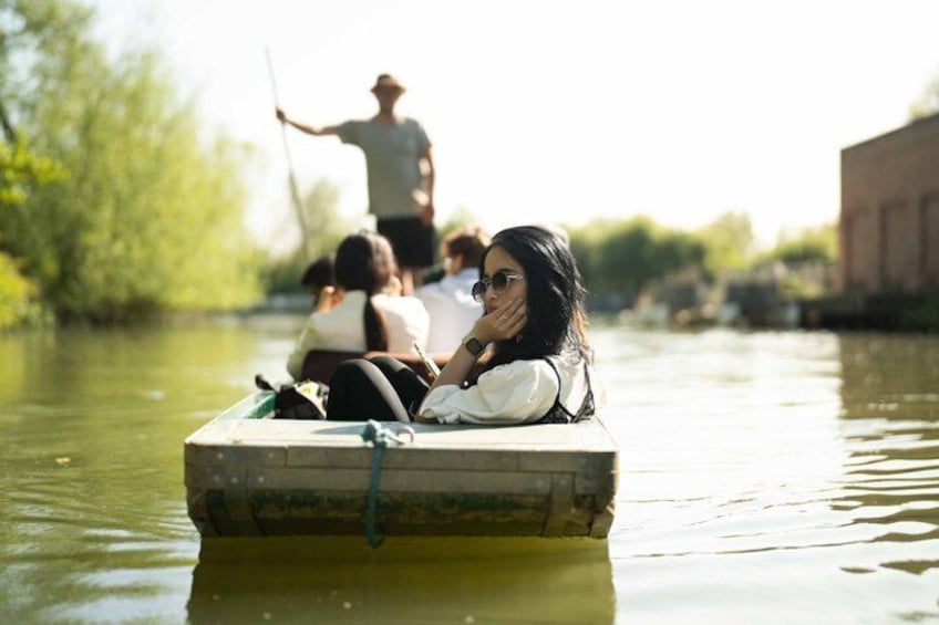 A narrow waterway with a small boat carrying passengers. 1
