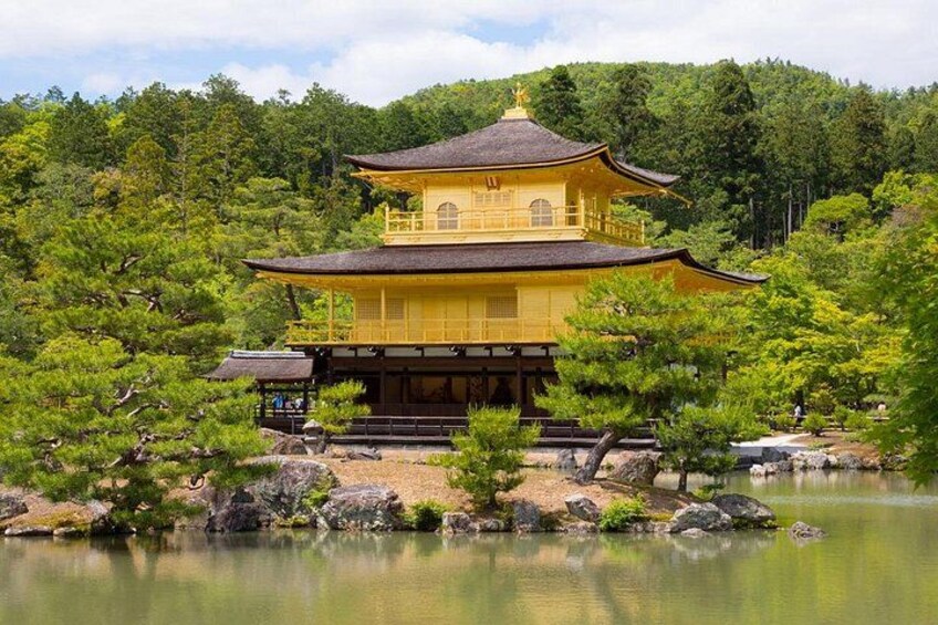 A traditional Japanese building with a multi-tiered roof, surrounded by a serene pond and lush greenery. 2
