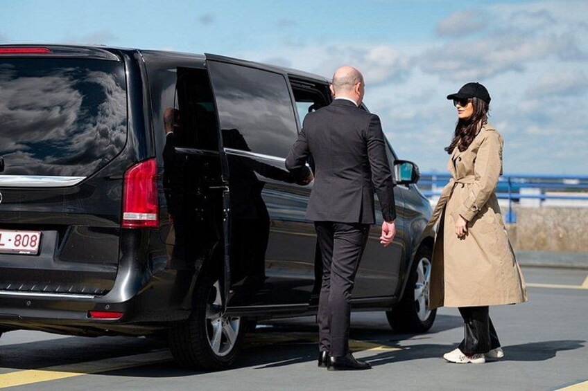 A man and a woman standing next to a black SUV with its door open. 3
