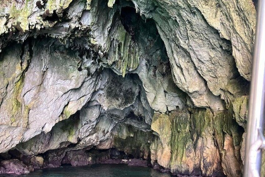 A cave interior with rugged rock formations and a water pool at the bottom. 5