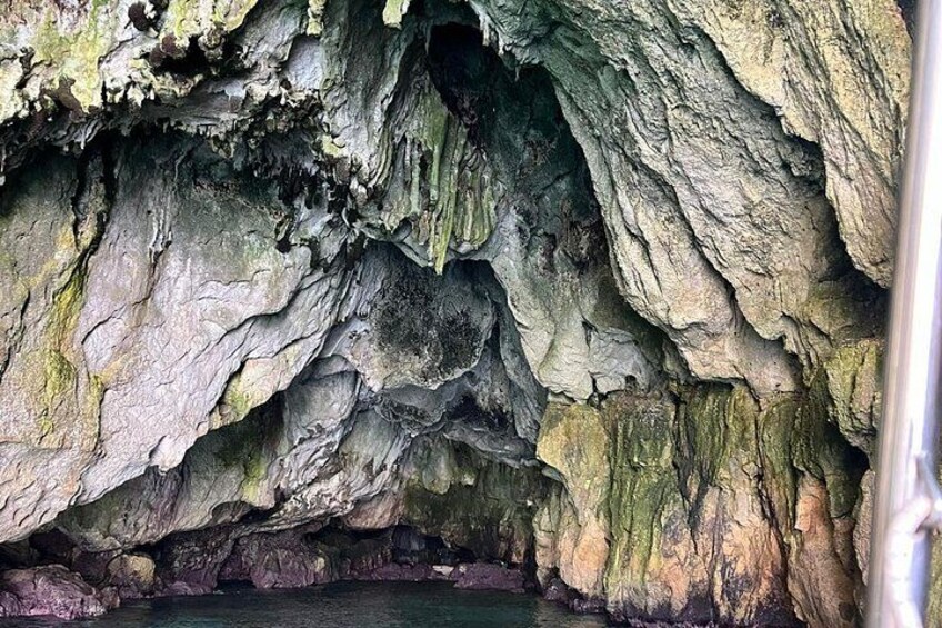 A cave interior with rugged rock formations and a water pool at the bottom. 5