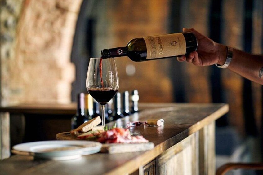 Une personne qui verse du vin rouge dans un verre. 2