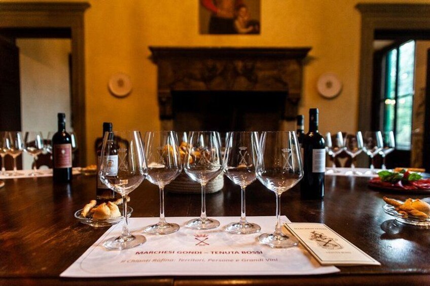 Une dégustation de vins, avec des verres à vin vides alignés sur une table, un menu et des bouteilles de vin en arrière-plan. 3