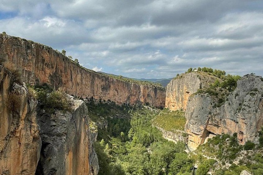A canyon with steep cliffs and dense greenery. 5