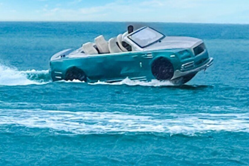 A teal convertible car driving on water. 1