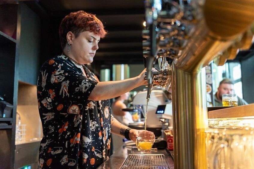 Una persona sirve una bebida de un grifo en un vaso. 5