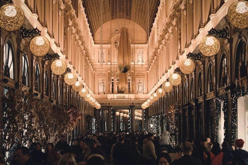 An ornate hall with chandeliers, columns, and a crowd of people. 5