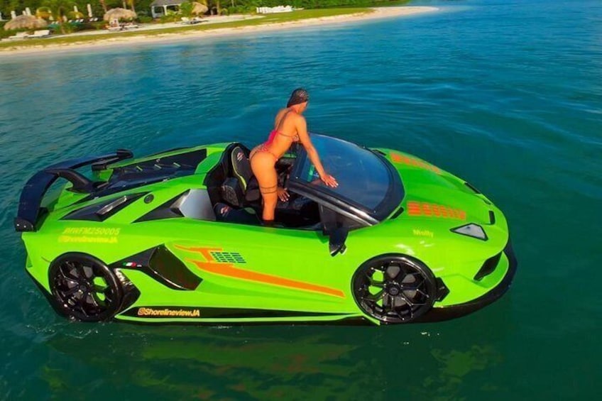 A bright green jet ski with a person on it, water, and a beach in the background. 2