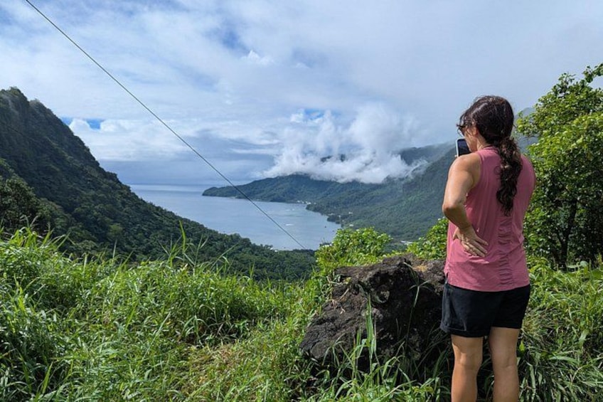 Una persona fotografiando un paisaje montañoso con un lago y nubes. 4