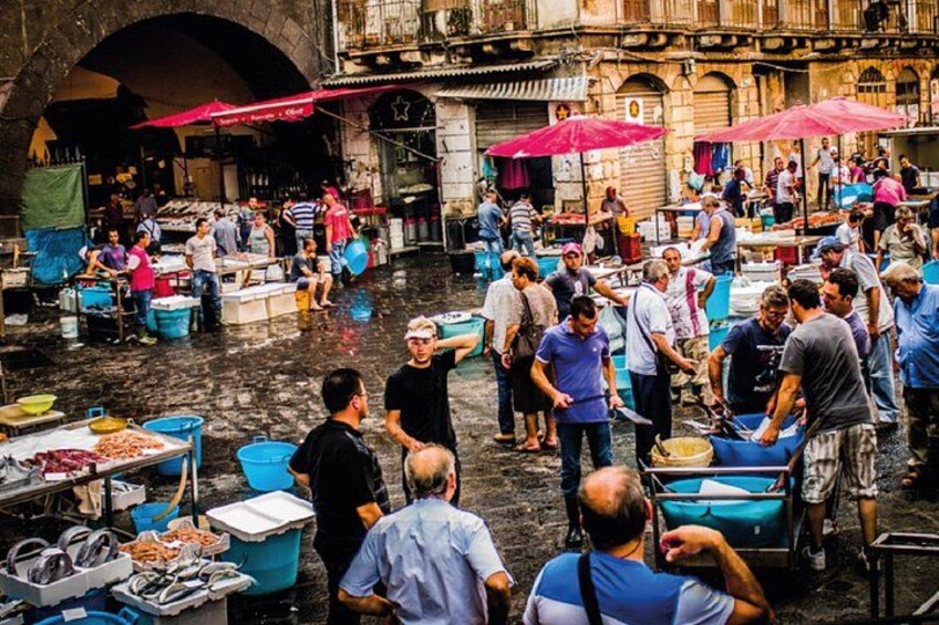 A bustling outdoor market with people shopping and vendors selling goods. 2