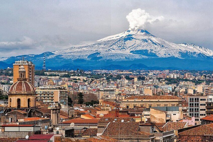 A cityscape with a prominent church and a volcano in the background. 3
