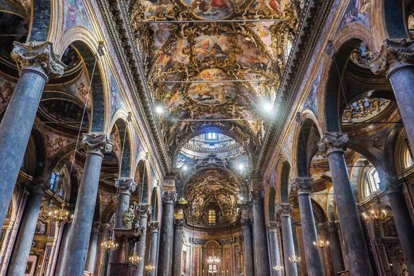 An ornate church interior with high ceilings, detailed frescoes, and classical columns. 3