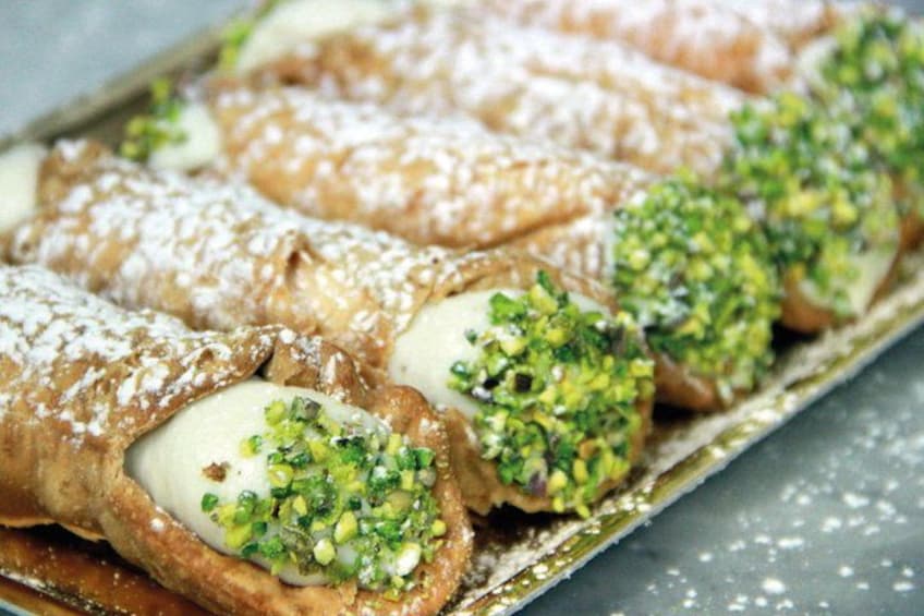 Una bandeja de pasteles con azúcar glas y pistachos picados. 4