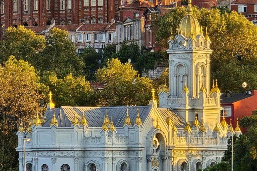 Una iglesia histórica con arquitectura ornamentada, una imponente torre campanario y un fondo de edificios residenciales. 5