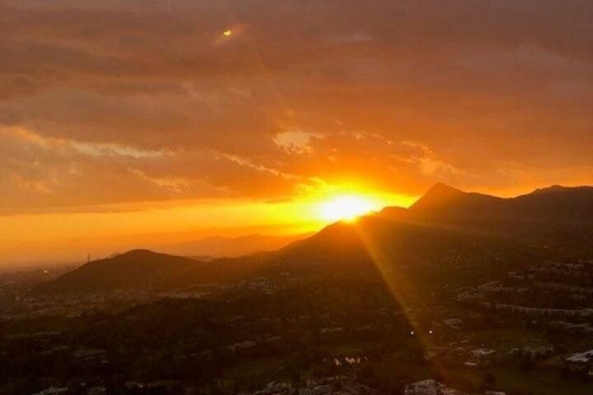 A sunset over a mountainous landscape with a city in the foreground. 4