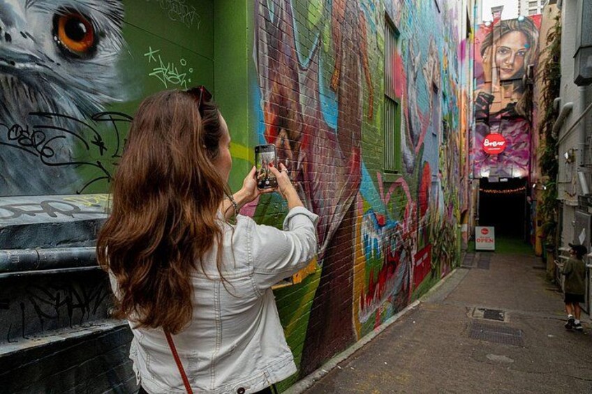 Une personne prend une photo d’une fresque murale colorée. 2