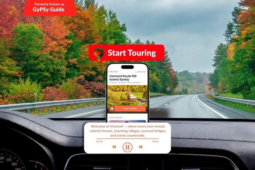 Un teléfono inteligente sobre el tablero mostrando un tramo panorámico de la carretera estatal 100 de Vermont, con follaje otoñal. 1