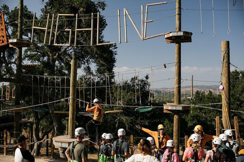 An outdoor adventure course with ropes and wooden structures. 2