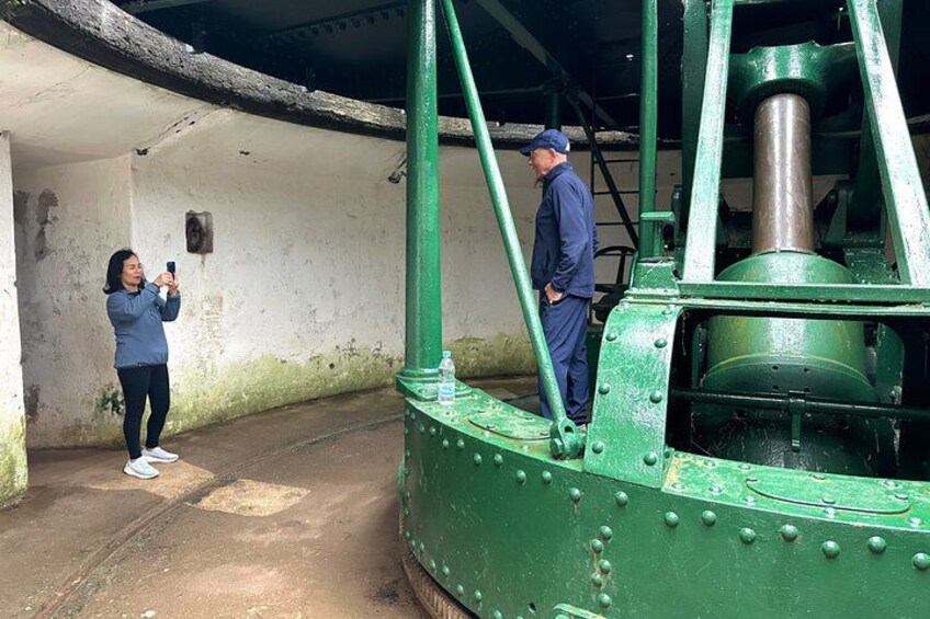 A person taking a photo, a large green industrial machine, and a man standing beside it. 3