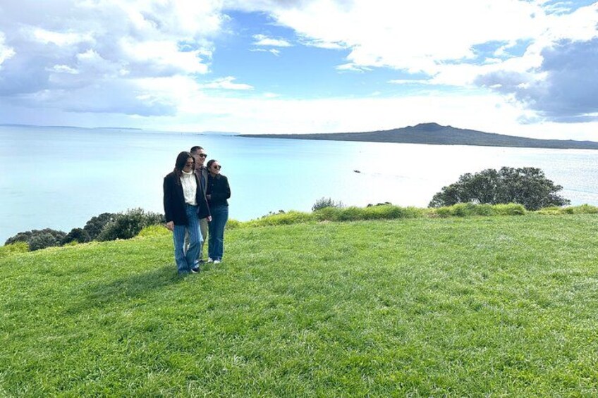 Un campo cubierto de césped con una masa de agua y una montaña distante. 5