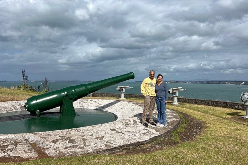 A green cannon, a body of water, and a cloudy sky. 3