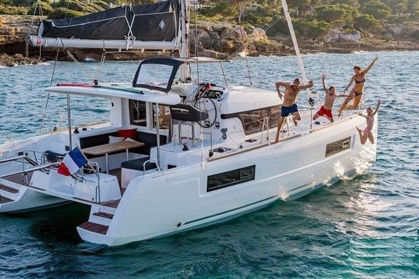 A white yacht with people jumping off the bow. 1
