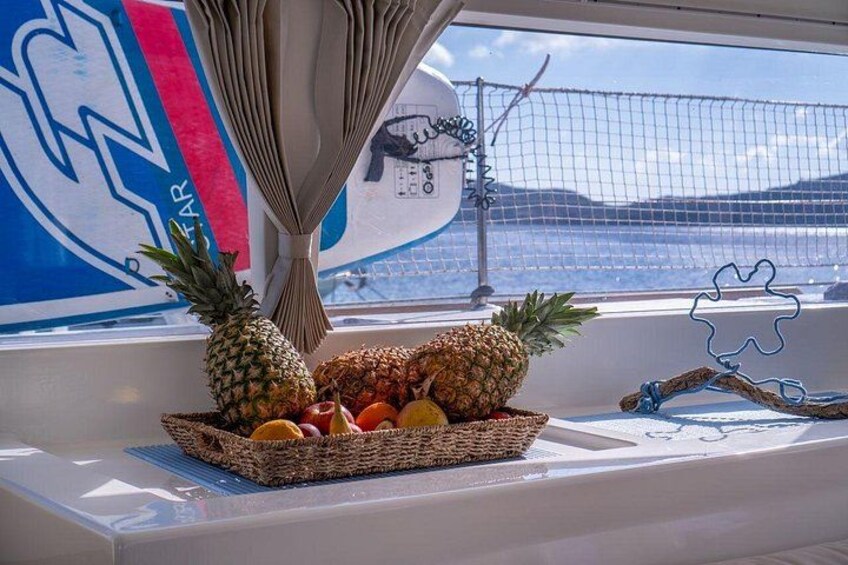 Une fenêtre avec un panier de fruits, une planche de surf et un espace délimité par un filet. 2
