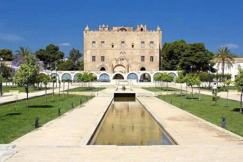 A historic building with arched windows and a central courtyard with a reflecting pool. 2