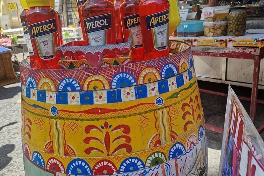 A colorful display stand with bottles of Aperol liqueur. 3