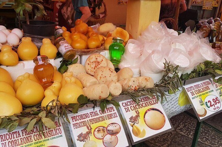 A market stall with various fruits and vegetables, including lemons, oranges, and garlic. There are also signs with prices and product names. 4