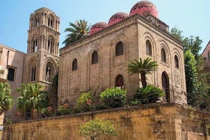 A historic building with domed roofs and a bell tower. 4